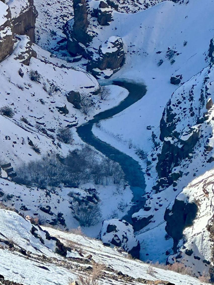 A river winding through a snow-filled gorge