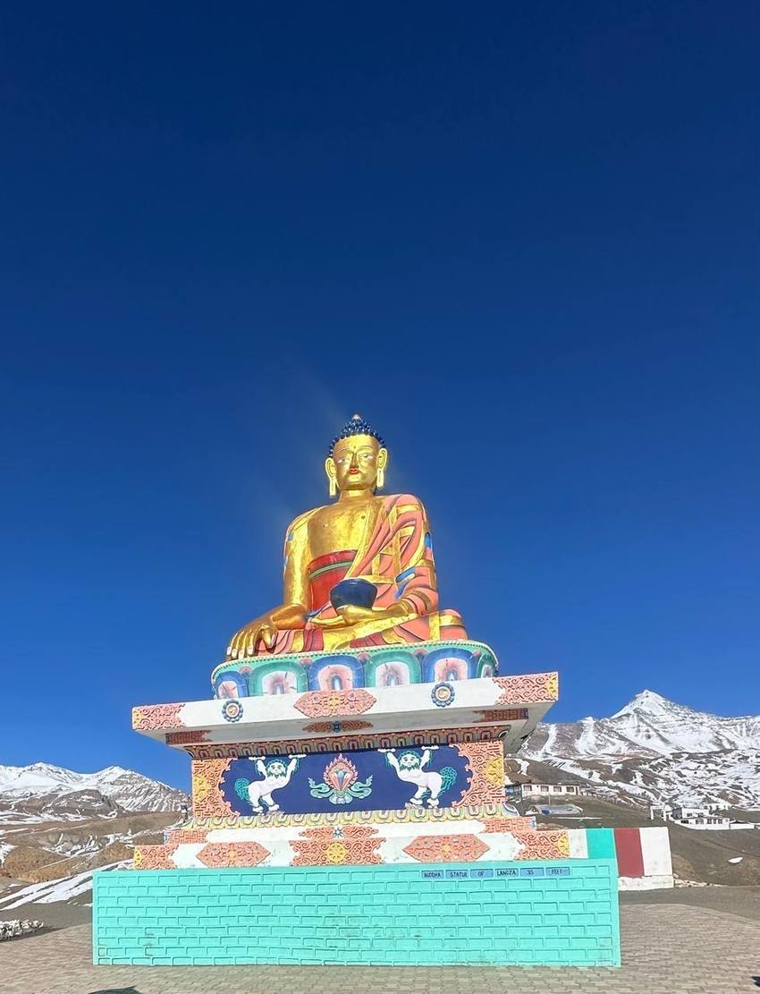 The golden Buddha statue at Langza under a deep blue sky