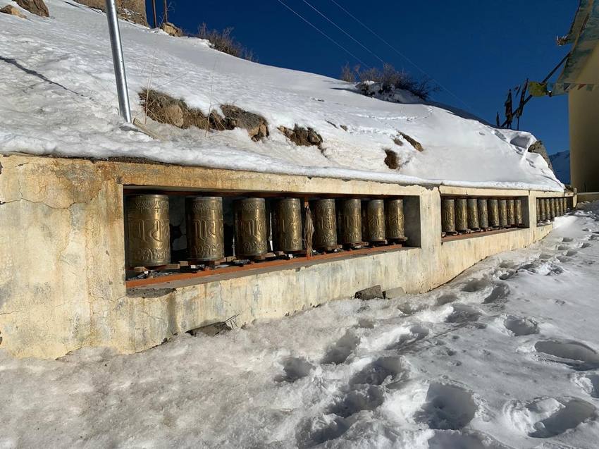 Prayer wheels set into a snowy wall