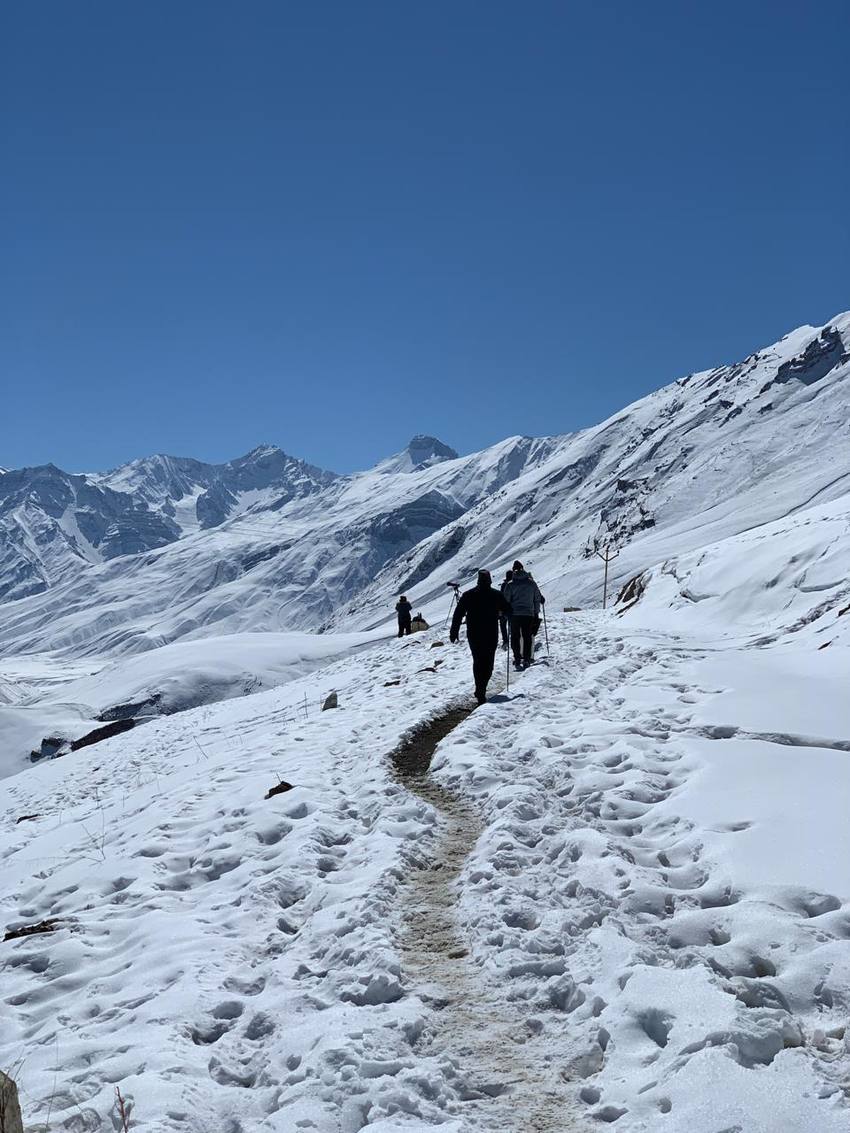 The group walking a snowy trail into the mountains